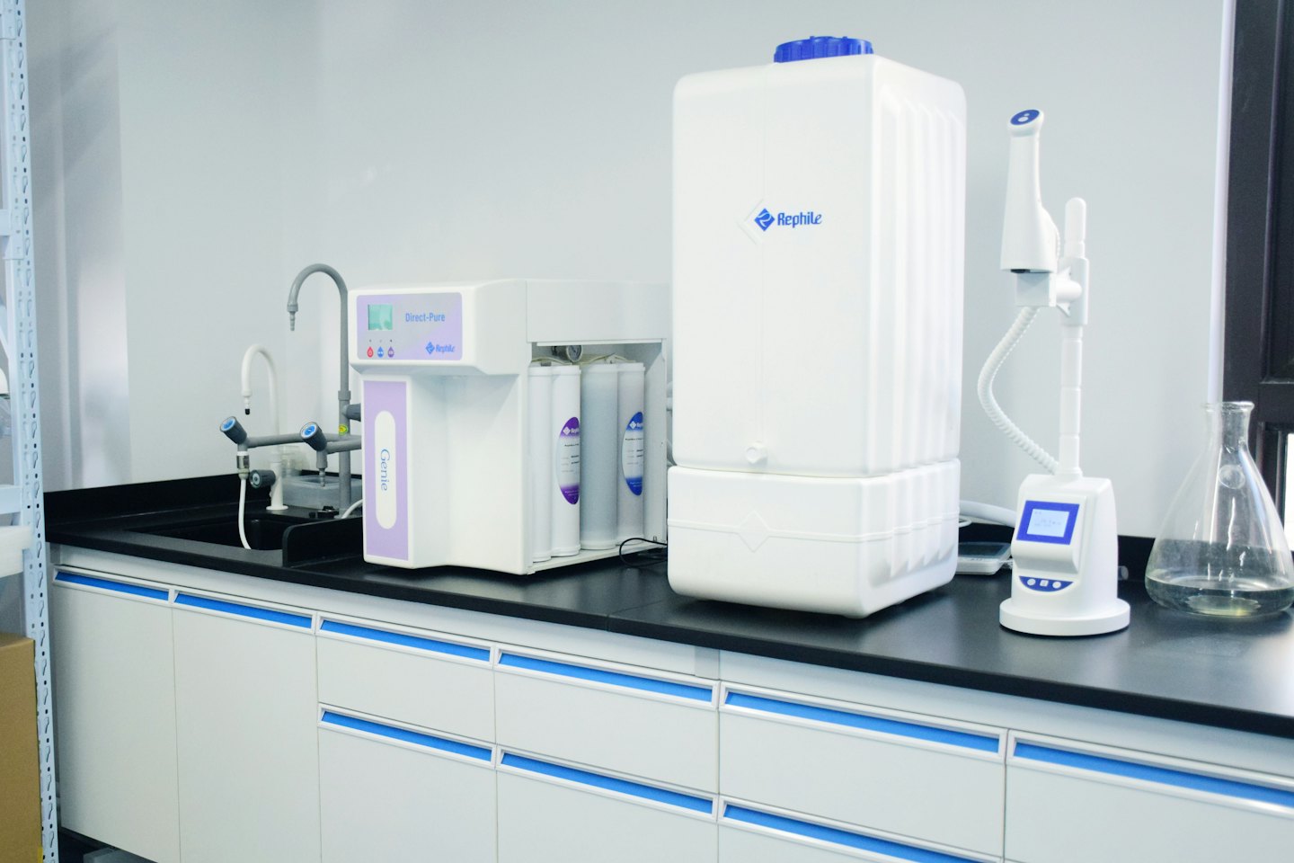 Laboratory water purification systems on a black countertop.